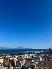 Fototapeta premium Coastal view of a bustling town with clear skies and serene waters at midday