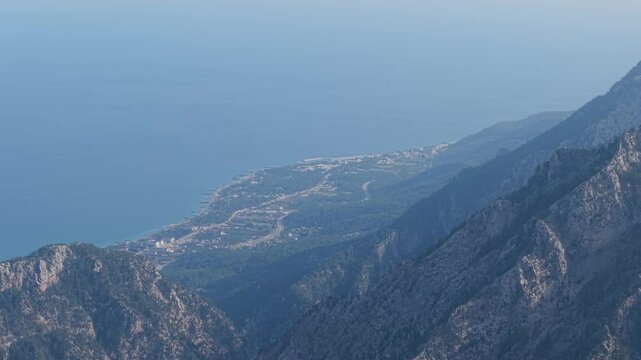 High-resolution aerial footage of Beldibi's coastline in Antalya, Turkey, featuring clear turquoise waters and the Beydağları Mountains.