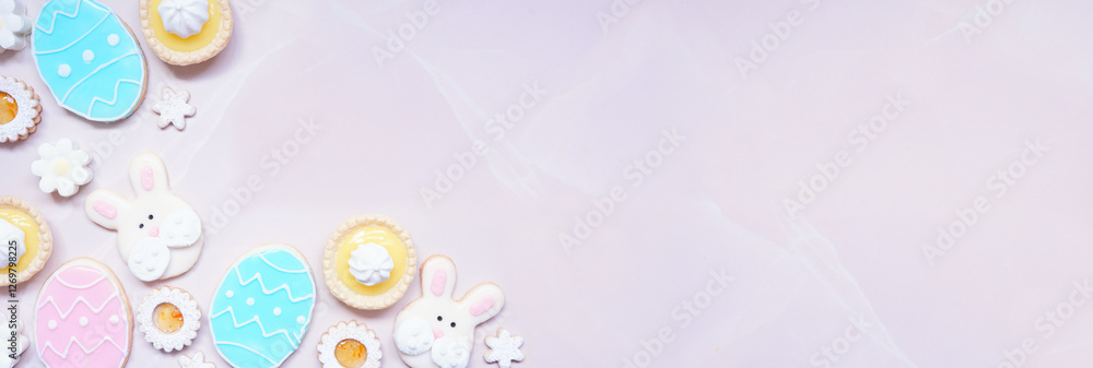 Poster easter or spring themed baking corner border with assorted cookies and sweet desserts. overhead view
