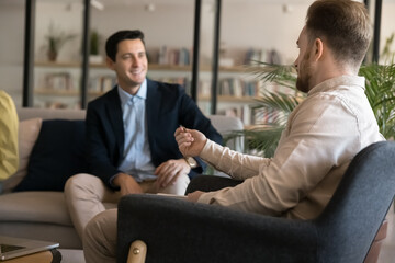 Casual conversation. Two young businessmen entrepreneurs students rest at library relaxation area...