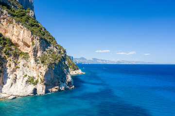 Naklejka premium The cliffs around Cala Goloritze beach in Baunei in Europe, Italy, Sardinia, Baunei, in summer, on a sunny day.