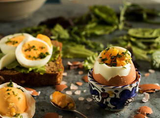 gekochtes Ei im eierbecher und als Brotbelag mit grünen salat