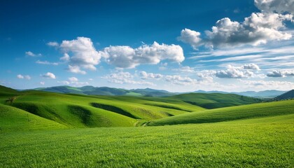 Obraz premium serene green landscape rolling hills under blue sky fluffy white clouds peaceful nature scenery open fields bright daylight clear weather idyllic rural view