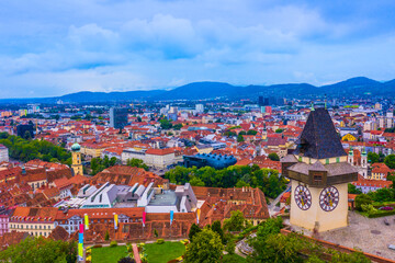 A stunning view of the historic Uhrturm Clock Tower in Graz, Austria, with its iconic design in the foreground and the beautiful cityscape of Graz stretching out in the background