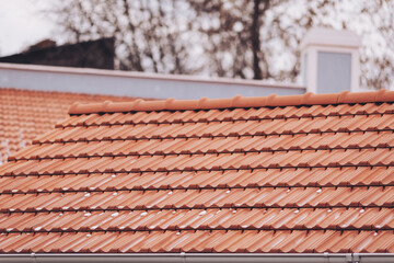 a little snow rest on the warm terracotta tiles,  in a quiet neighborhood. The rooftops create a picturesque landscape filled with charm and character