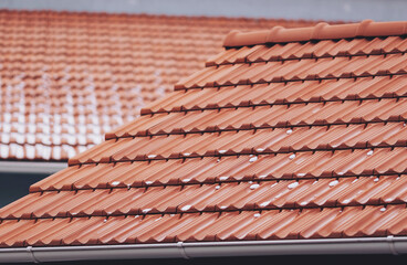 a little snow rest on the warm terracotta tiles,  in a quiet neighborhood. The rooftops create a picturesque landscape filled with charm and character