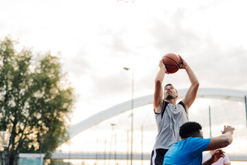 Basketball player shooting ball during game on outdoor court