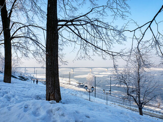 Winter view of the Kama River, bridge and descent to the embankment. Large ice floes are floating along the Kama. Snow covers the ground. Landscapes of the city of Perm. Russia. 2025.