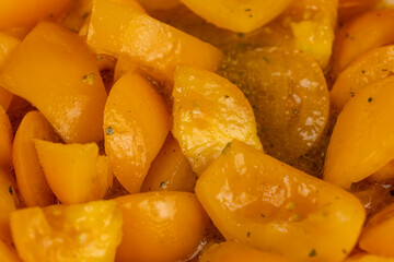 ripe orange tomatoes with spices cut into pieces of different sizes