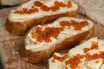 a soft loaf of wheat flour with butter and red salmon caviar