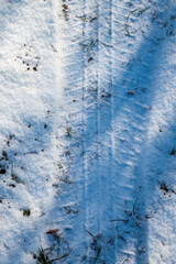 Tire tracks in fresh snow on the ground
