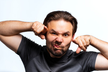 Young man making bull horn gesture , portrait isolated on white