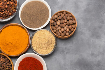 Spices in bowls turmeric, paprika, cardamom, black and allspice. Top view with space for copying.