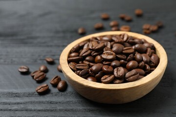 Fresh coffee beans in a wooden bowl on a wooden background