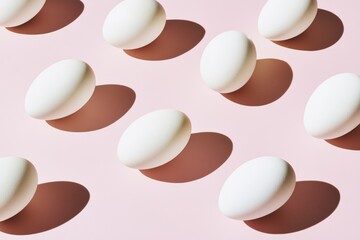 Fototapeta premium Minimalist white eggs pattern on pastel background with artistic shadows