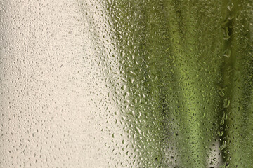 Soft focus green leaf grass through glass with wet water drops. Abstract nature blur background.