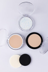 A Collection of Cosmetic Powders and Application Sponges on a Clean White Background for Makeup Enthusiasts and Beauty Tutorial Aspirants