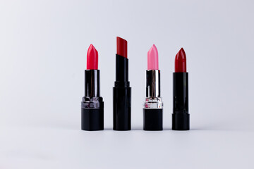 A Stunning Display of Four Vibrant Lipsticks in Various Shades for Makeup Lovers Seeking the...