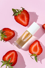Strawberry-infused lip oil in a sleek glass bottle on a pink background. Hydrating, glossy, and nourishing formula for soft lips. Perfect for beauty, skincare, and lip care routines. Lip oil.
