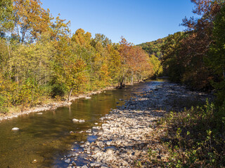 Stream near Seneca Rocks, West Virginia, on sunny day with trees in fall colors