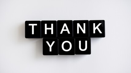 Black tiles with white letters spell out thank you