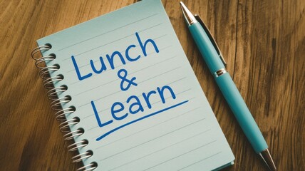 A notepad with lunch and learn is placed on wood