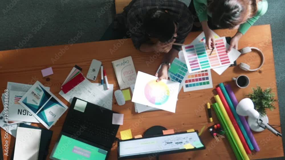 Poster top down view of smart designer helping manager choosing color from colored palettes. aerial view of