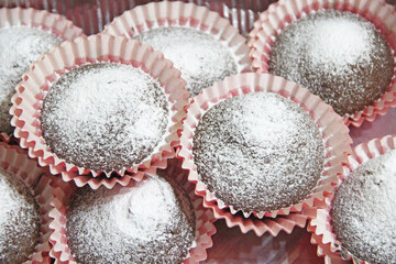 Sweet muffins. Pile of fresh cupcakes. Delicious cupcakes on counter close-up. Cake sale. Pile of cupcakes in candy store. Confectionery factory products. Cupcake sprinkled with powdered sugar