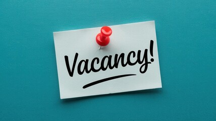 Vacancy announcement posted on a blue wall with a pin