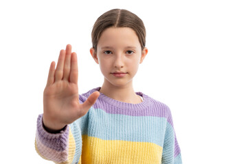 A young girl in a colorful sweater holding her hand up in a stop gesture against a white background.