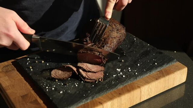Steak cut into thin pieces and slices on a dark background