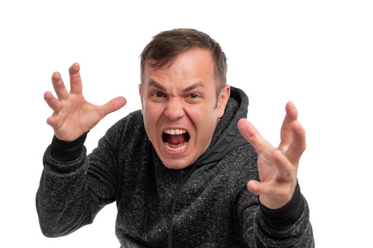 A young man in a gray hoodie showing anger and frustration with a fierce expression against a white background. - Powered by Adobe