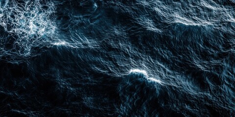 Dark ocean waves with dramatic white foam and deep blue textures