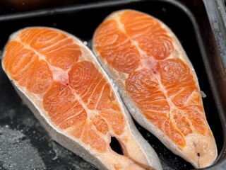 Atlantic salmon steaks from frozen raw materials on a substrate on a showcase for sale in a supermarket