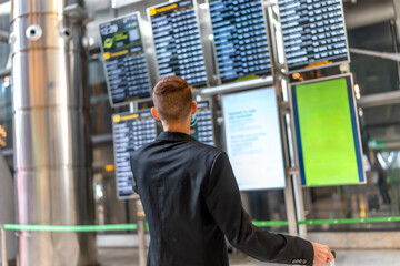 Businessman checking flight information on airport panel