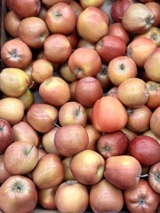 Box filled with fresh juicy natural bio organic red apples placed on counter in local food market