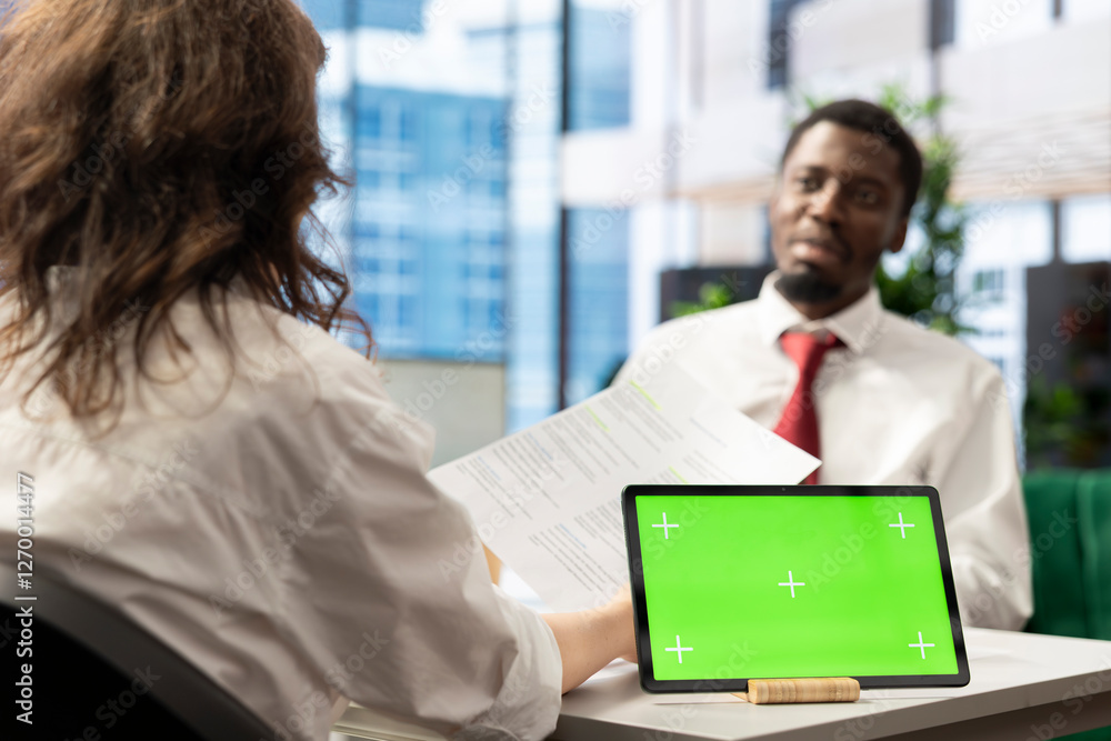 Poster employer conducts interview with jobseeker using isolated screen tablet to determine suitability for