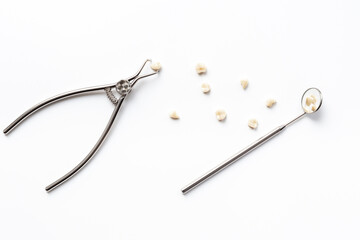 Dental teeth crowns and steel instrument for dental prosthetics, top view. Dentist desk, white...
