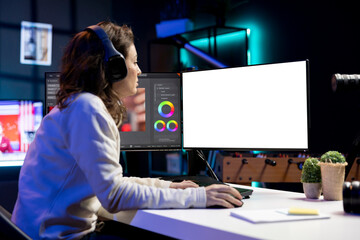Video editor using editing software on isolated screen monitor to upgrade footage shot,...