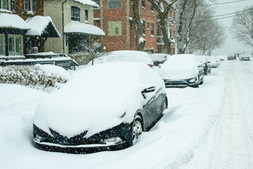 time to dig out: snow covered cars parked on snow choked residential street after a major winter...