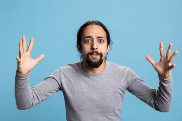 Frustrated angry person expressing his intense emotions and anxiety on camera, showcasing anger management issues and rage. Young adult being furious and irritated with something in studio.