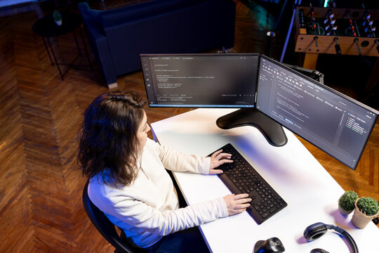 Woman doing software quality assurance, reading source code on computer screen before implementing it. System administrator inspecting coding on desktop PC, looking to fix potential issues
