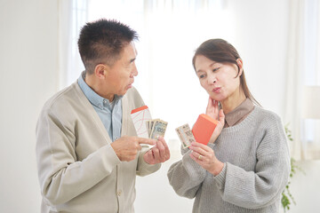 ポチ袋を持って考えるシニア男性と女性
