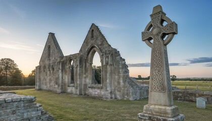Fototapeta premium Celtic cross beside monastery ruins with intricate designs at sunrise in a soft light