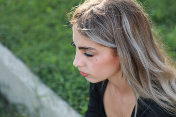 Naklejka premium Contemplative Woman Sits Under a Shady Tree