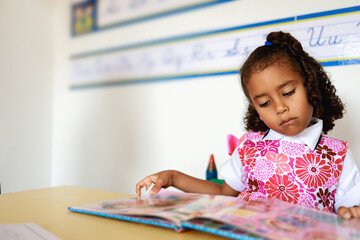 Black kid student learn to read in classroom at kindergarten school room. Education concept