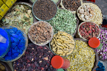 Curry in root and various spices displayed in a local bazaar market in Marrakesh