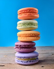 Colorful Macarons Stacked on Wooden Surface with Blue Background
