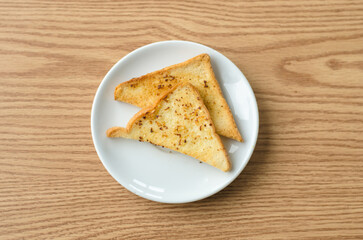 two grilled bread with butter on a white plate.