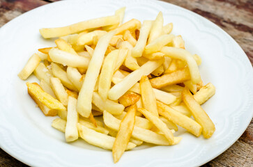 Crispy golden French fries on a white plate